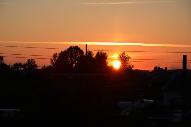 Güzel gece gökyüzü. Evlerin çatısında turuncu gün batımı. Yatay fotoğraf.