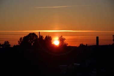 Şehrin üzerinde güzel bir günbatımı. Turuncu gece gökyüzü. Yatay fotoğraf.