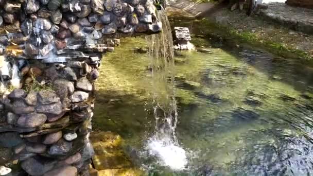 Schöner Wasserfall mit einer Steinrutsche. Dekorativer kleiner Wasserfall im Landschaftsbau. — Stockvideo