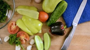 Dilimlenmiş sebzeler masada salatayı dilimlemeye hazır. Bulgar biberi, domates, otlar, salatalık, sebze yemekleri için sarımsak.