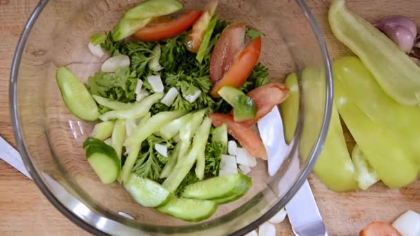 Las verduras cortadas en rodajas están sobre la mesa, listas para rebanar ensalada. Pimienta búlgara, tomate, hierbas, pepino, ajo para cocinar platos de verduras. Ensalada de verduras preparada . — Vídeo de stock