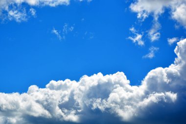 Açık güneşli bir günde mavi gökyüzünde beyaz bulutlar. Güzel bir atmosferik fenomen. Doğal yatay arkaplan.