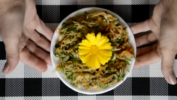 Mettez une tasse de salade, décorée d'une fleur de souci, sur la table. Salade de chou-rave, d'oseille, de radis et d'aneth. Plat diététique. — Video