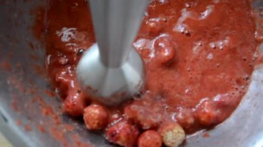 Çilekler blender ile ezilir. İçkinin hazırlanması için çilekler olgunlaşmıştır. Smoothie için İçecekler.
