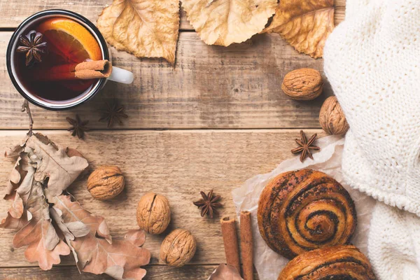 Traditional mulled wine in mug with pastry and spice on wooden background