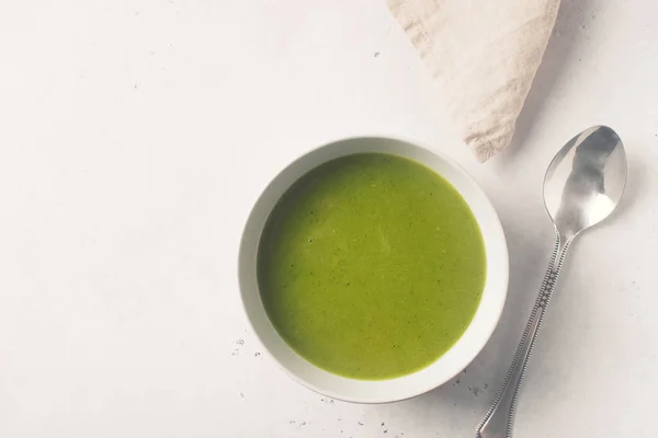 Green vegetable soup on white background minimalism, copy space, top view