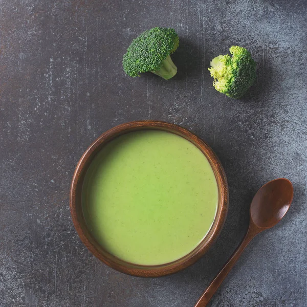 Green vegetable broccoli soup on dark grey background copy space, top view, square