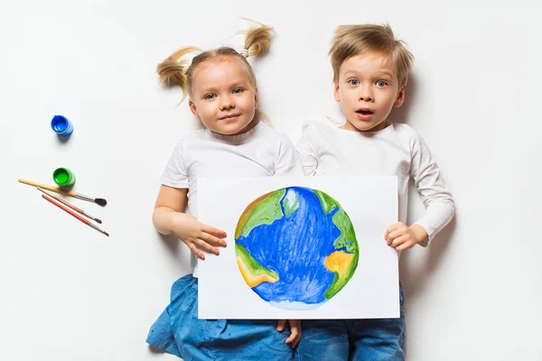 Ecology concept with two prety little kids painting sad earth on