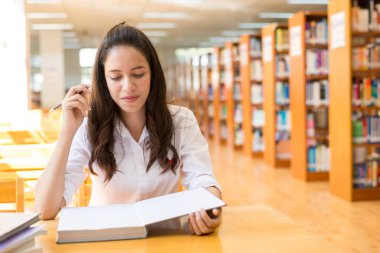 kitaplığındaki kitap okumak güzel Hint üniversiteli kız