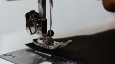 Erkek terzi el dikiş makinesi tekstil ve giyim için kumaş dikiş arkasında deri tutan. Atölyede dikiş makinesinin çalışma sürecini yakınlaştın. Tekstil sanayi, üretim ve moda