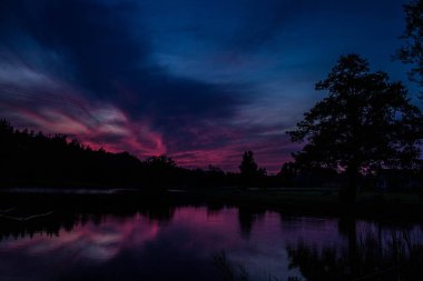 Göl ve orman üzerinde güzel pembe günbatımı! Arka plan.