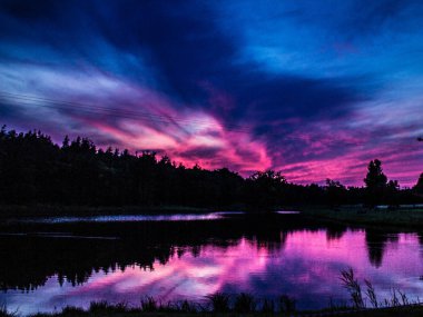 Göl ve orman üzerinde güzel pembe günbatımı! Arka plan.