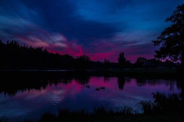 Göl ve orman üzerinde güzel pembe günbatımı! Arka plan.