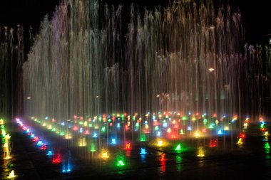 Gece aydınlatmalı renkli bir çeşme. Muhteşem bir çeşme. Arka plan.