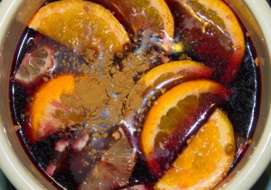 Mulled şarap bir tencerede pişirilir. Portakal ve tarçın ile mulled şarap.