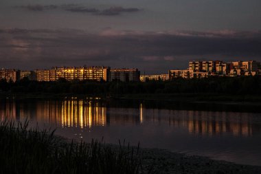 Gece şehri. Evlerin ışığı suya yansır. Arka plan. Doku.