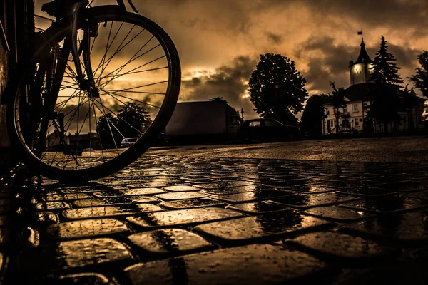 夜の雨の街 石を敷く ぬれた通り 日没時の自転車 世界は素晴らしいです — ストック写真