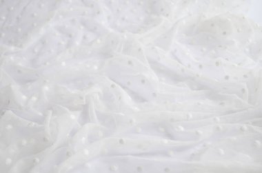 Arkaplan beyaz dantel, ışık kıvrımlı, ince kumaş ve noktalı.