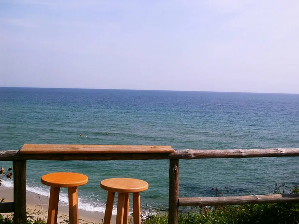Retro photo, sea and two chairs in an open bar, sea horizon