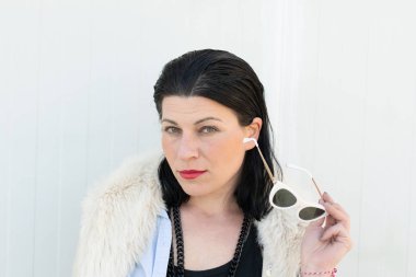 Güneş gözlüğü ile poz veren bir kadın modelportresi.