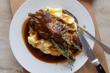 Et suyu ve patates püresi ile pişirilmiş domuz pirzolası.