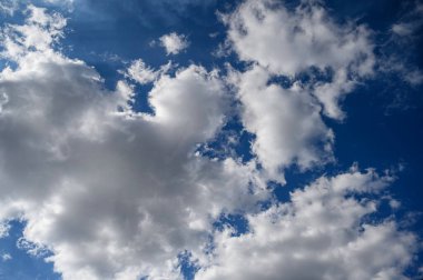 Üzerinde kabarık bulutlar olan dramatik gökyüzü. Yüksek kaliteli fotoğraf kabarık bulutlarla dolu mavi bir gökyüzünün çarpıcı görüntüsü, seyahat promosyonları, doğa reklamları veya sakin arka plan tasarımları için ideal.