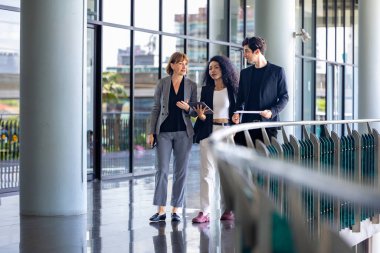 Çeşitli iş adamları yeni proje ve planlama için ofis binasında dolaşırken yatırım gayrimenkulleri üzerine yeni stratejik strateji projeleri üzerinde tartışıyorlar.