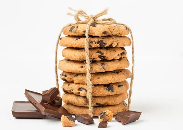 Stack of cookies with chocolate drops with chocolate pieces on white background