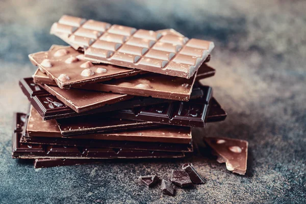 Stack of collection delicious chocolate bars on wooden background