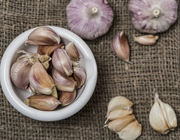 Garlic bulbs with cloves of garlic on brown sackcloth