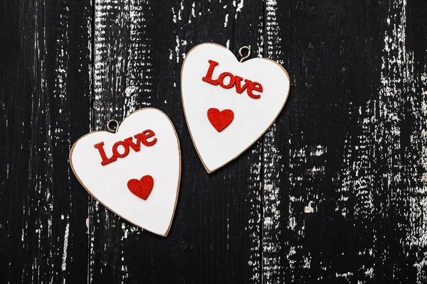 Cute hearts with lettering on wooden surface