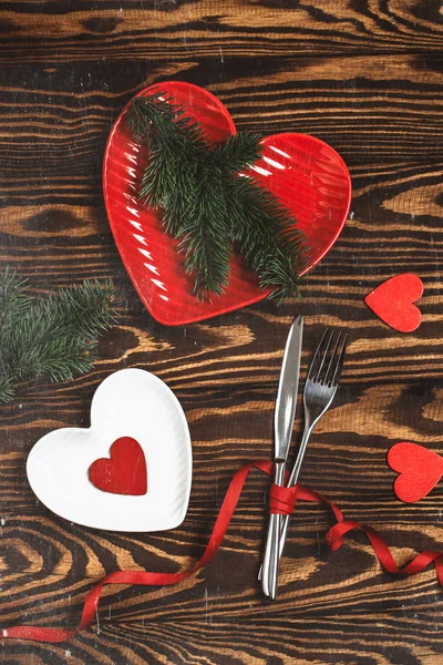 Festive table setting for Valentines day with hearts and fir branches