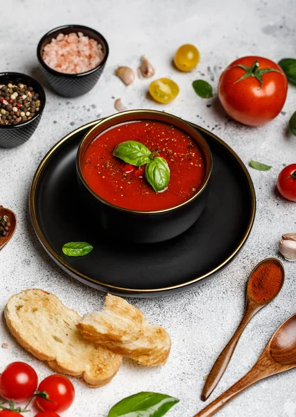 Traditional Spanish cold tomato soup gazpacho in a bowl on stone background. Traditional Spanish food. Concept of Spanish cold soup made of ripe tomatoes. Copy space, closeup