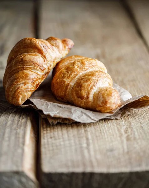 Appetizing croissants isolated on wooden background