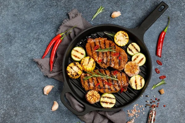 hot grilled steaks on fry pan with sliced corns and squash, delicious dish
