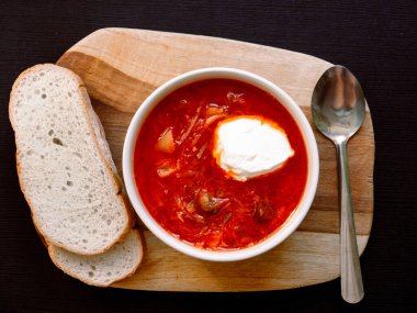 Koyu arkaplanda beyaz ekmek olan Ukrayna kırmızı borsch 'u. Geleneksel Rus mutfağı. Üst görünüm, düz uzanma