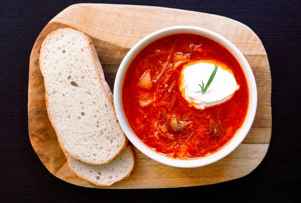 Tahta üzerinde kırmızı kremalı Ukrayna borsch 'u. Üst görünüm, metin için boş alan.