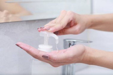 El dezenfektanı jel pompası kullanan kadın elleri..