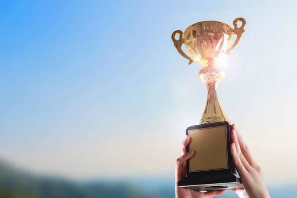Trophy Kupası gökyüzü arka plan üzerinde tutan eller iş.