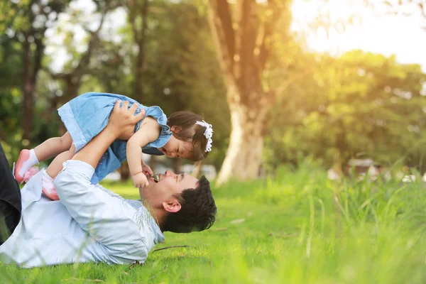 Vader en meisje spelen liggen op gras, lage hoek — Stockfoto
