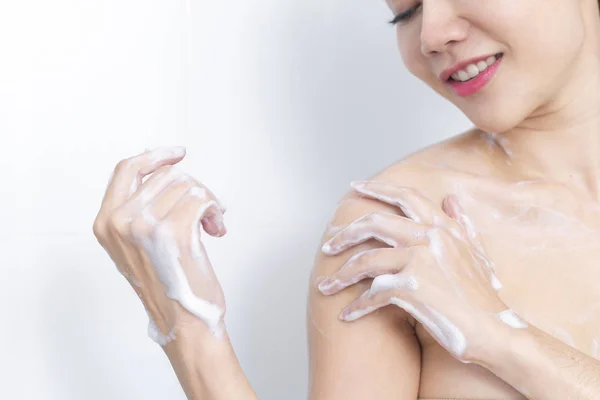 Frau unter der Dusche genießt Wasser, das auf sie spritzt. — Stockfoto