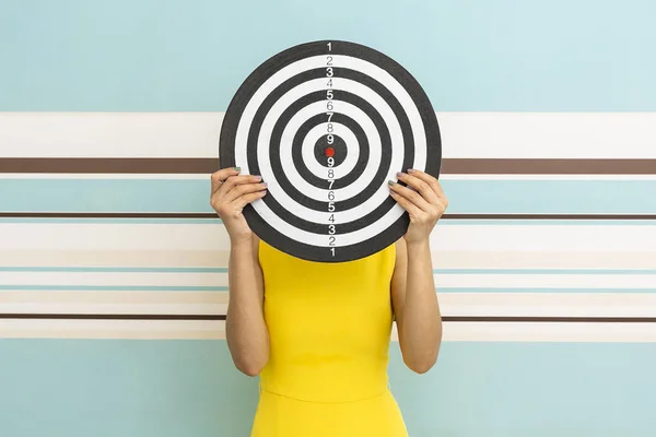 Goals concept with young woman holding target on blue background — Stock Photo, Image