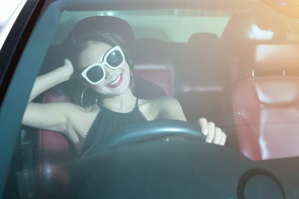 Jovem mulher atraente sorriso agradável em casual enquanto dirige um carro . — Fotografia de Stock