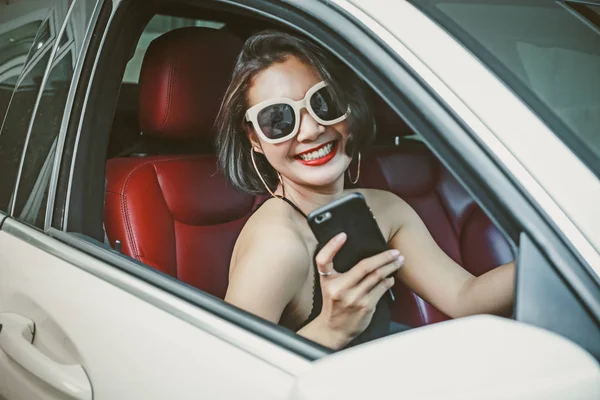 Jovem mulher dirigindo o carro e falando telefone na estrada . — Fotografia de Stock