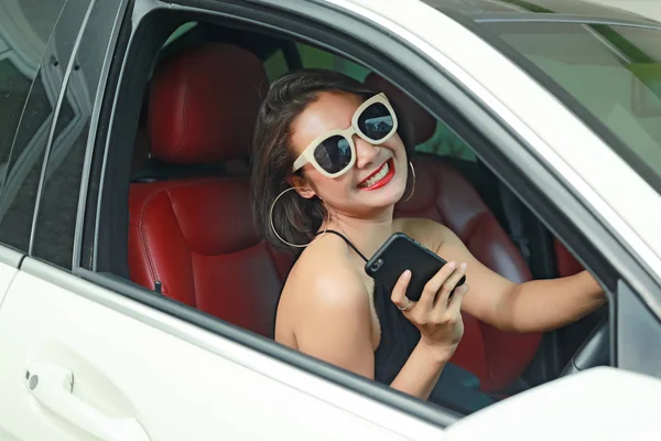 Jovem mulher dirigindo o carro e falando telefone na estrada . — Fotografia de Stock