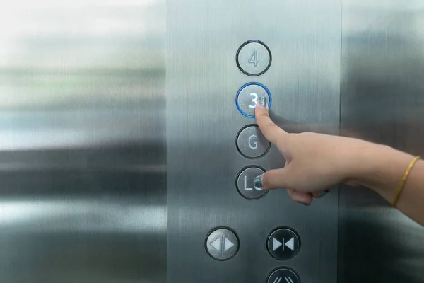 Close up waman hand drücken Sie eine Taste des Fahrstuhls. — Stockfoto