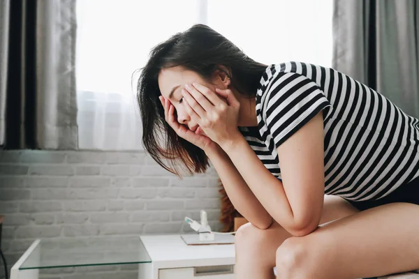 Mulher triste deprimido sentado em um sofá na sala de estar . — Fotografia de Stock