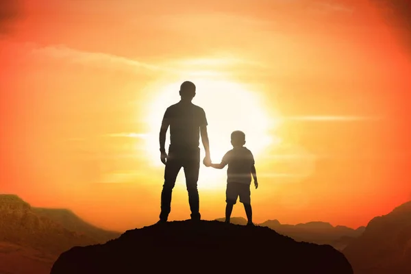 Отец и сын держатся за руки на закате . — стоковое фото