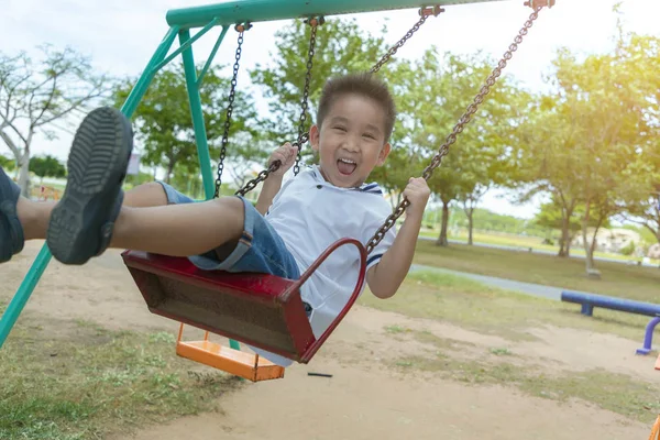 Criança brincando engraçado no playground ao ar livre no parque . — Fotografia de Stock