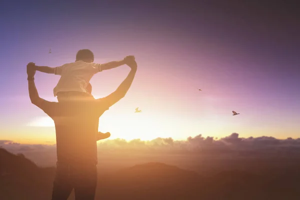 Sohn reitet mit seinem Vater bei Sonnenuntergang im Freien. Vatertag — Stockfoto